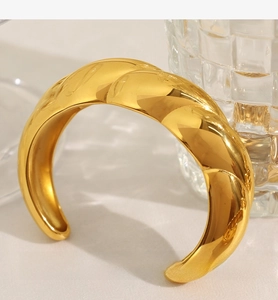 Macro shot of gold twisted lava texture open cuff bracelet with high polished mirror finish
