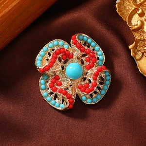 Macro shot of retro geometric flower brooch with turquoise beads and golden base