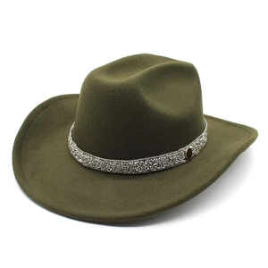 Close-up of olive green felt hat featuring a rhinestone band and metallic M letter charm