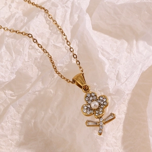 Makroaufnahme von 18K Gold Blumenanhänger mit glitzernden Strasssteinen und Perle