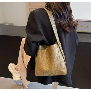 Detailed weave texture on olive green faux leather tote bag worn by a model