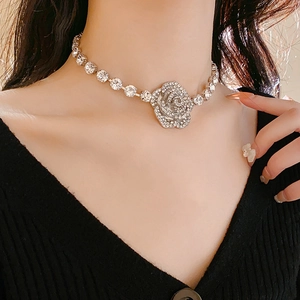 Vue détaillée du collier fleur argenté serti de diamants sur le cou d'un mannequin