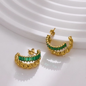 Detail of C-shaped gold twisted hoop earrings featuring rectangular green zircon inlay