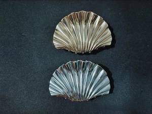 Detailed top view of gold and silver seashell metal hair claws with wavy texture