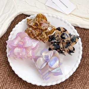 Elegant acetate rose flower hair claws in iridescent pink, blue, and tortoiseshell patterns