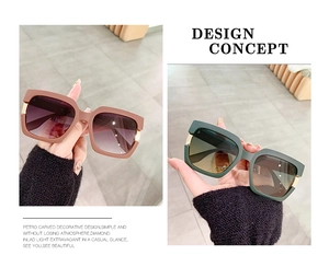 Detail of square oversized sunglasses showing golden metal hinges and gradient lenses