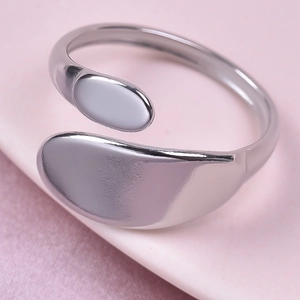 Macro shot of silver-tone wrap ring with dual smooth oval ends on a pink background
