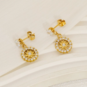 Macro detail of gold-plated starburst earrings with sparkling zircon stones