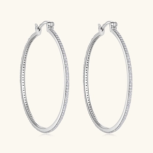 Macro detail of silver oversized hoop earrings with shimmering white moissanite stones
