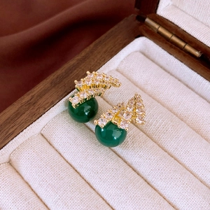 Detail of vintage earring with green resin bead and sparkling zircon inlay in a jewelry box