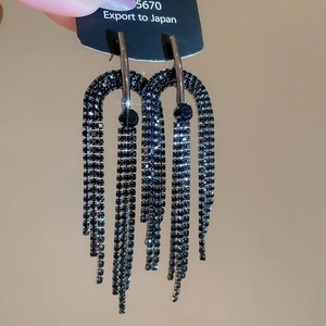 Détail de longues boucles d'oreilles en argent avec strass bleu marine brillants