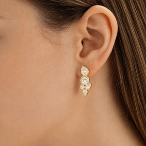 Detail of gold teardrop zircon earrings shown on a model for a luxury jewelry look