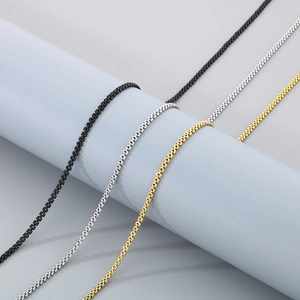 Detailopname van roestvrijstalen visgraatkettingen in zwart, zilver en goudkleur