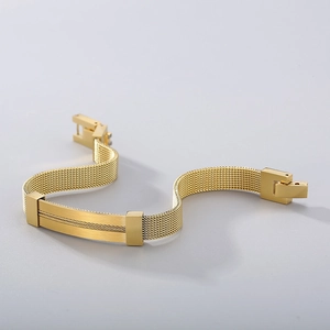 Detailed macro view of golden stainless steel mesh woven bracelet with a curved metal plate
