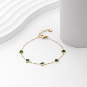Gold heart bracelet with five green zircon stones on a minimalist stainless steel chain