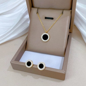 Close-up of gold titanium necklace and black agate earrings in a luxury jewelry box