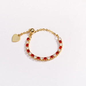 Detail of adjustable gold chain ring featuring red and white zircons and heart charm