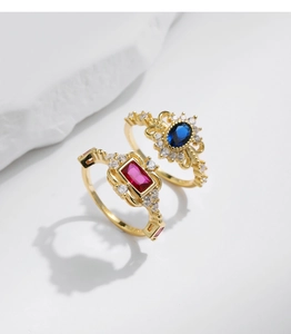 Detailed macro view of vintage gold plated rings with red and blue gemstone settings
