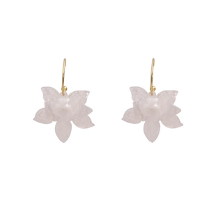 Macro shot of white translucent flower earrings with gold hooks on white background
