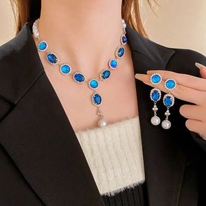Dettaglio del set collana con zaffiri blu e perle indossato da una modella fashion