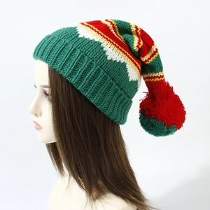 Detailed view of red and green striped knit Christmas hat with large fluffy pom-pom