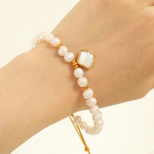 Elegant natural freshwater pearl bracelet with a gold-framed white shell petal charm