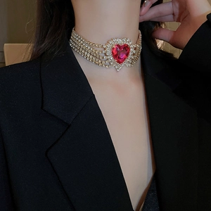 Close-up of elegant gold choker with five rows of diamonds and a red heart gemstone