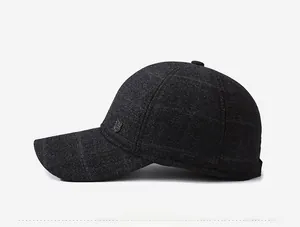 Détail de l'emblème métallique en forme de bouclier et de la laine à carreaux sur la casquette