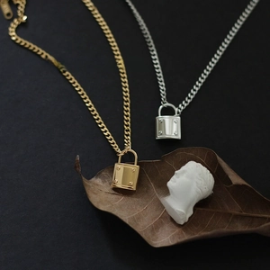 Artistic detail of gold and silver square lock pendants on a hip hop chain necklace