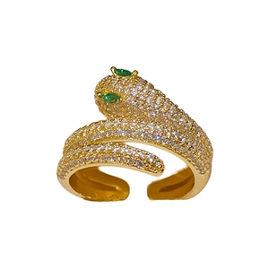 Adjustable snake-shaped ring in gold finish with sparkling zircons and green gem eyes