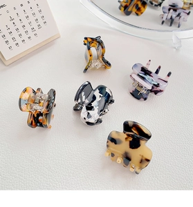 Detailed close-up of premium acetate hair claws with leopard and tortoiseshell patterns