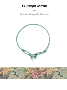 Detailed macro of a mint green braided cord bracelet with a blue dragonfly pendant charm