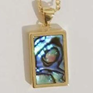 Macro shot of rectangular gold shell pendant with iridescent blue and green inlay detail