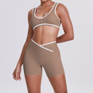 Detail of khaki yoga set showing cross waist design and white contrast piping on the shorts
