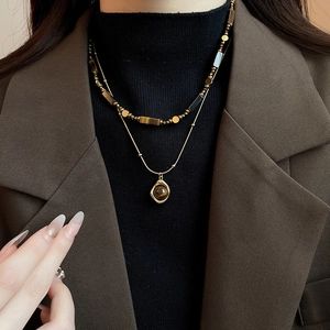Close-up of double-layer gold plated necklace with tiger eye stone on a model