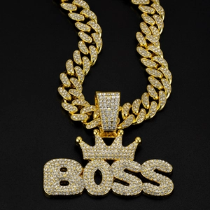Macro shot of gold-plated Cuban chain necklace with a rhinestone-studded BOSS crown pendant