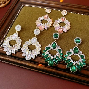 Détails de boucles d'oreilles géométriques de luxe avec strass roses, blancs et verts