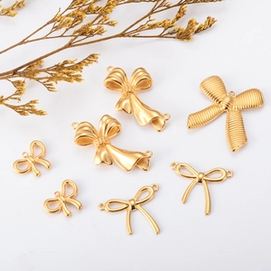 Close-up of assorted golden bow-shaped metal charms and DIY jewelry accessories