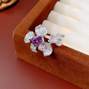 Macro detail of a purple floral brooch with zircon stones on a brown velvet jewelry box