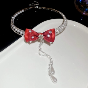 Detail of red bow pearl necklace with crystal tassels and sparkling rhinestone inlay