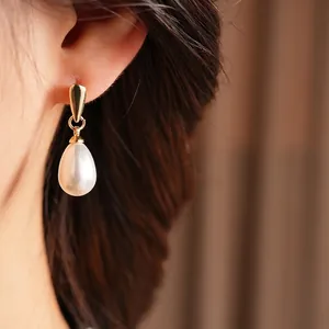 French vintage waterdrop pearl earrings with elegant gold hooks shown on a model