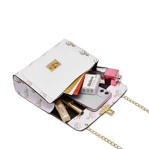 Mini white crossbody bag with gold horse print showing interior storage for daily items