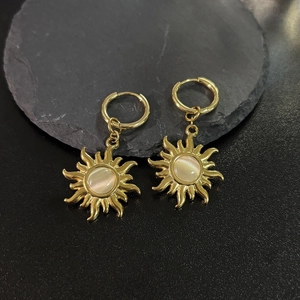 Macro shot of 18K gold plated sun earrings with round cat-eye stone on stone plate