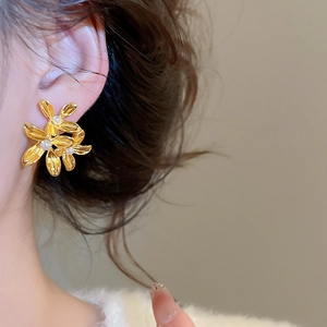 Detailed macro view of vintage gold flower earrings with elegant white pearl centers