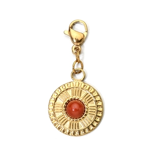 Close-up of golden stainless steel pendant with red gemstone and lobster clasp