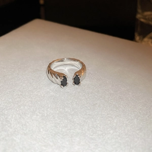 Macro shot of silver open ring featuring two marquise-cut black stones and twisted band
