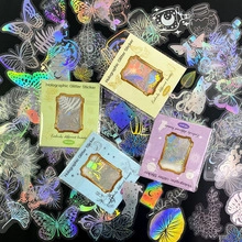 Close-up of holographic glitter stickers featuring laser-cut butterfly and moon designs