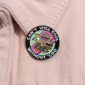 Round metal badge featuring a cartoon bird on a skateboard with 'CAN'T SPELL COOL WITHOUT COO' text
