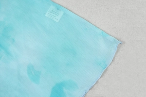 Detail of turquoise A-line dress fabric with printed care label and fine texture