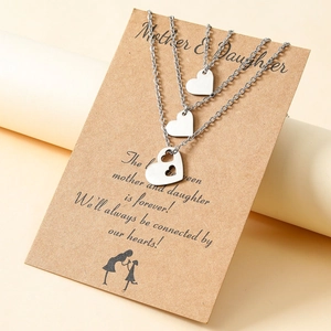 Macro shot of silver heart mother-daughter necklace set on a kraft greeting card